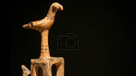 Foto de Canakkale, Turquía - 19 de noviembre de 2023 Principios de la Edad de Bronce Estatuilla de arcilla anatólica de un pájaro sobre un fondo negro. Exposición de arte antiguo en el Museo Arqueológico - Imagen libre de derechos