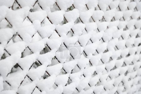 Photo for Winter, snowfall. Snow covered metal mesh. Diffused light and selective focus - Royalty Free Image