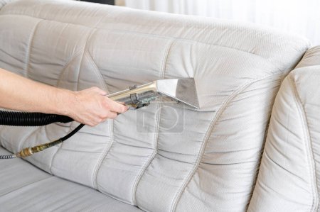 Concepto de empresa de limpieza comercial. Limpieza profunda del sofá mediante un dispositivo. Antes y después. Limpieza regular a principios de primavera.