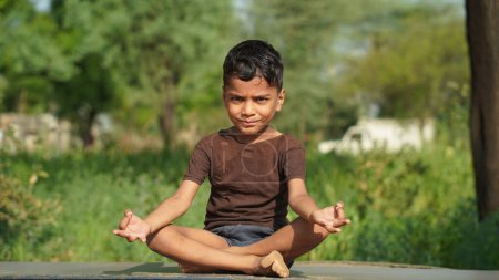 Photo for Little boy doing yoga in garden on beautiful nature background. - Royalty Free Image
