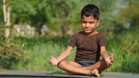 Photo for An indian boy doing yoga outdoors . Healthy and peaceful lifestyle - Royalty Free Image