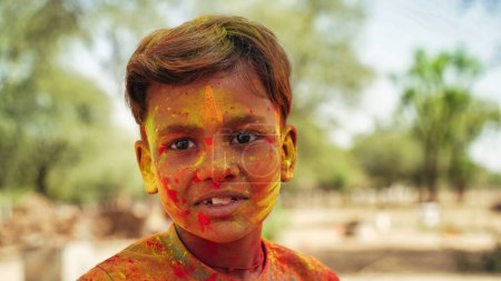 Foto de Retrato de Little Boy jugando con Colors. Concepto Holi. Niño cubierto de polvo de colores durante el festival de color en Rajasthan - Imagen libre de derechos