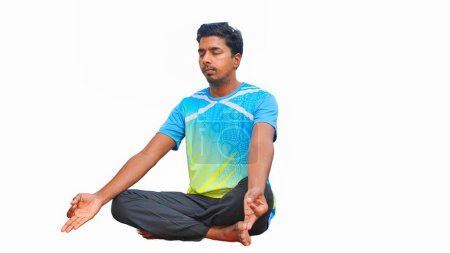 Foto de Joven indio en traje deportivo haciendo yoga y meditando sobre un fondo blanco - Imagen libre de derechos