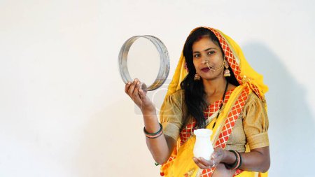 Téléchargez les photos : Jeune femme indienne célébrant karwa chauth en costume traditionnel avec plein de bonheur - en image libre de droit