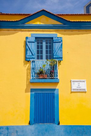 Photo for At Aveiro, Portugal, On 30-08-2023-vibrant yellow and blue window and door of an house of the old town - Royalty Free Image