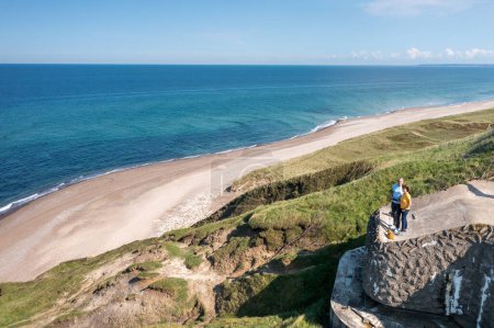 Téléchargez les photos : L'homme est assis sur le bord des falaises en Irlande. la vue sur les falaises et la mer. la vue depuis le sommet de la vue aérienne sur la plage et les falaises Bulbjerg Danemark - en image libre de droit