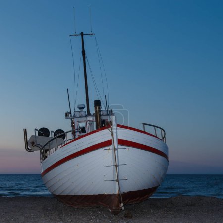 Téléchargez les photos : Bateau de pêche dans une mer au coucher du soleil - en image libre de droit