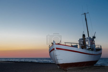 Photo for Fishersboat in a sea at sunset - Royalty Free Image