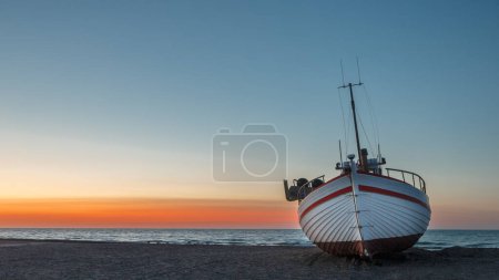 Téléchargez les photos : Bateau de pêche dans une mer au coucher du soleil - en image libre de droit