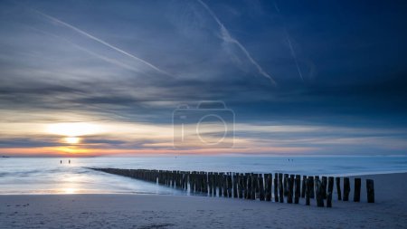 Sonnenuntergang an der Küste von Vlissingen Holland mit den Holzpfählen