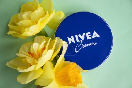 Photo for May 1, 2022 Ukraine city Kyiv jar of Nivea cream, narcissus flower on a colored background - Royalty Free Image