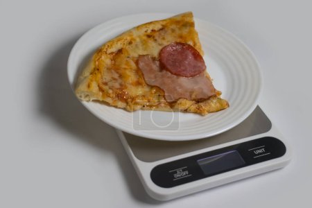 Photo for Piece of pizza kitchen scales on a light background - Royalty Free Image
