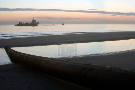 Photo for A dredger vessel taking and supplying sand for coastal protection - Royalty Free Image