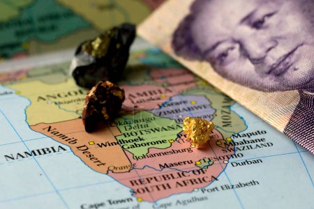 Foto de Primer plano de un billete chino yuan y metales de tierras raras encima de un mapa de África - Imagen libre de derechos