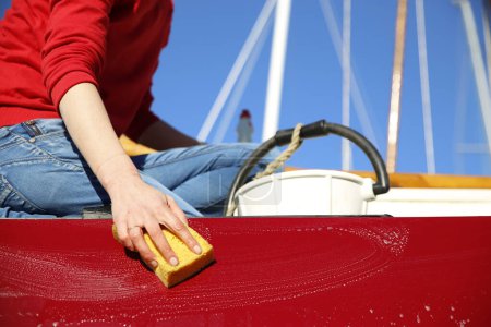 Téléchargez les photos : Gros plan d'une jeune femme nettoyant son bateau dans un port de plaisance, Hollande - en image libre de droit