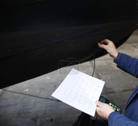 Foto de Ingeniero de servicio que mide el espesor del casco de acero de un barco mediante un dispositivo ultrasónico - Imagen libre de derechos