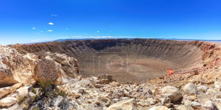 Photo for Barringer Meteor crater near Winslow, Arizona; observation platform visible, showing the immense scale. Weathered rocks, desert plants in the foreground. Clear blue sky in above. - Royalty Free Image