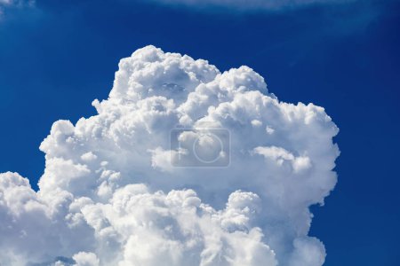 Closeup of Billowy cumulus clouds. Wispy clouds, deep blue sky in background. 
