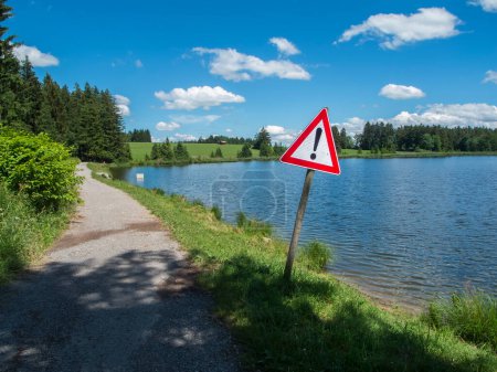 Photo for Road sign at the edge of the Pond Koegel in summer with a blue sky and small white clouds. - Royalty Free Image