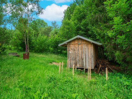 Téléchargez les photos : Petite cabane de travailleur forestier à la lisière d'une forêt verte près de la ville de Nesselwang en Bavière. - en image libre de droit