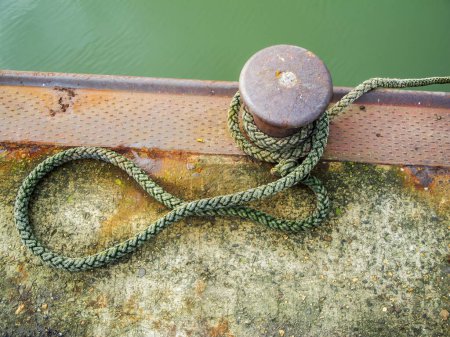 Foto de Vista superior de una pilona con cuerda tendida en la orilla del puerto de Harlesiel en Frisia Oriental Alemania. - Imagen libre de derechos