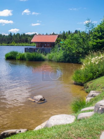 Photo for Landscape view with small swimming area and small fisherman's house on Bavarian Attlesee near the town of Nesselwang - Royalty Free Image