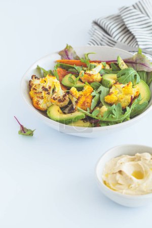 Téléchargez les photos : Salade d'hiver végétalienne chaude aux légumes, houmous et avocats, fond blanc. - en image libre de droit