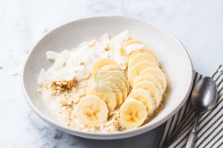 Photo for Overnight vegan oatmeal with banana and coconut chips. - Royalty Free Image