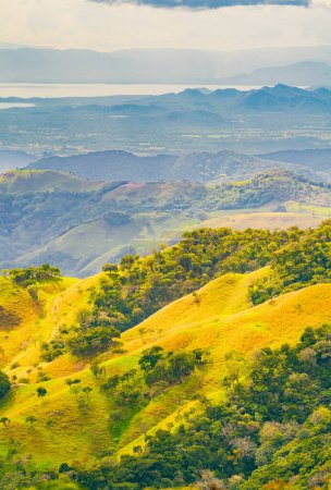 Pendientes verdes de Monteverde bajo un cielo dinámico, mostrando la rica biodiversidad y vistas en capas de montaña de la provincia de Puntarenas, Costa Rica. Foto de alta calidad