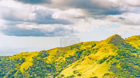 Pendientes verdes de Monteverde bajo un cielo dinámico, mostrando la rica biodiversidad y vistas en capas de montaña de la provincia de Puntarenas, Costa Rica. Foto de alta calidad