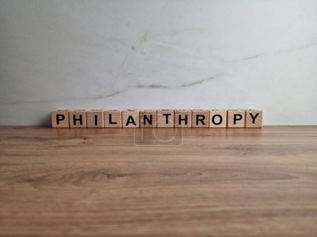 Philanthropie-Wort aus Holzklötzen auf Schreibtisch