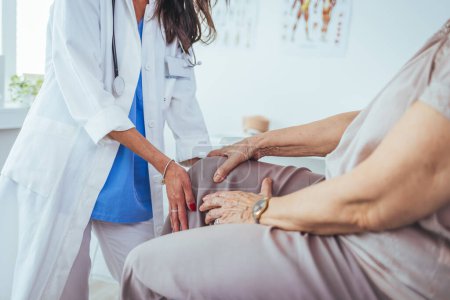 Photo for Doctor examining patient knee. Physiotherapist exam patient's knee. Senior patient with knee injury visit his physiotherapist. Doctor the traumatologist examines the patient the patient's ankle le - Royalty Free Image