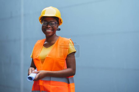 Photo for Young african - american worker in yellow safety hat and vest - Royalty Free Image