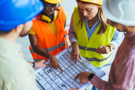 Photo for Group of people with blueprint at construction site. - Royalty Free Image