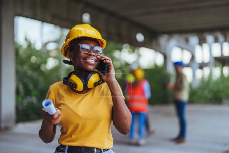 Photo for African worker using smartphone on construction site - Royalty Free Image