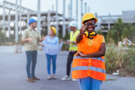 Téléchargez les photos : Travailleur africain en casque et gilet orange sur le chantier de construction - en image libre de droit