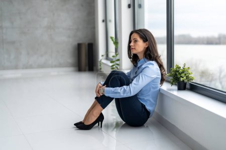 Photo for Sad businesswoman sitting on floor in the office - Royalty Free Image