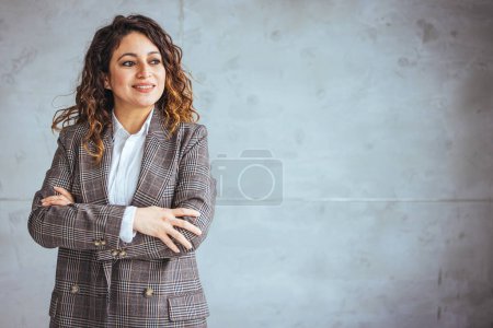 Photo for Cropped portrait of an attractive young businesswoman standing alone in her office with her arms folded during the day. Portrait of a businesswoman standing in a a modern office - Royalty Free Image