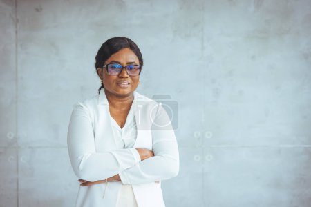 Photo for African american corporate worker standing in office. Portrait of confident young African American businesswoman isolated on orange studio background show leadership. - Royalty Free Image