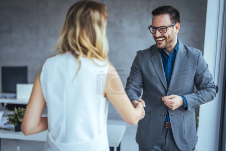 Photo for Portrait of cheerful young manager handshake with new employee. Close up of handshake in the office. Smiling businessman shaking hands while standing in an office. Handshake for the new agreement - Royalty Free Image