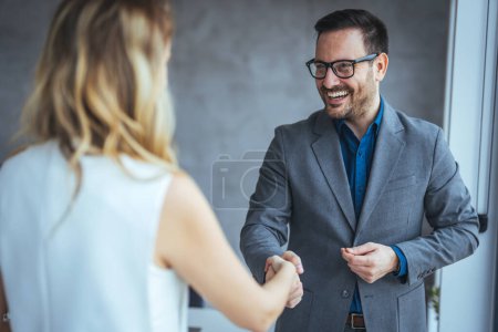 Photo for Sealing a deal! Two Business people shaking hands after Welcoming partners finishing up a meeting or setting goals and planning way to success in the office. Business people shaking hands in the office. - Royalty Free Image