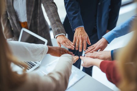 Photo for Teambuilding, Teamwork And Unity Concept. Below view of diverse group of smiling people putting their hands together, standing in circle. Multiethnic colleagues celebrating collaboration and alliance - Royalty Free Image