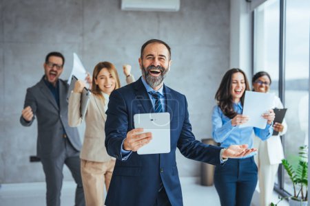 Photo for Excited group of coworkes embracing and jumping during a celebration. Business people smile and raise hands up, feeling happy, complete finish job, teamwork successful/achievement working in office concept - Royalty Free Image