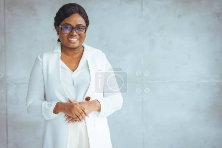 Photo for Happy smiling African American woman in formal isolated on gray background. Headshot of an african american businesswoman, CEO, finance, law, attorney, legal, representative - Royalty Free Image