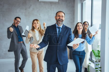 Photo for Those who work hard, win. Succesful enterprenours and business people achieve goals. Businesspeople cheering while brainstorming. Successful business group celebrating an achievement - Royalty Free Image