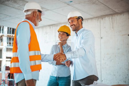 Photo for Woman architect or engineer looking at male colleagues handshaking at construction site - Royalty Free Image