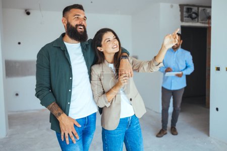 Photo for Real estate agent showing new apartment to young couple - Royalty Free Image