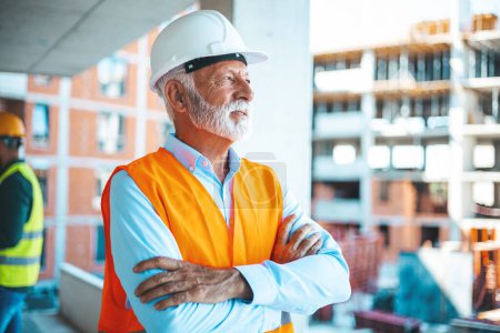 Photo for A senior construction site manager visually inspects a building project. Shot of a senior building contractor looking proud during a meeting. Smiling Chief Engineer with Tablet Reviewing Site - Royalty Free Image