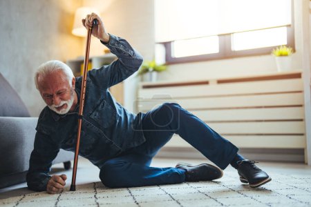 Photo for Sick senior old man falling down lying on the ground because stumbled at home alone with wooden walking stick in living room, elderly man grandfather having accident while walk with cane walker - Royalty Free Image