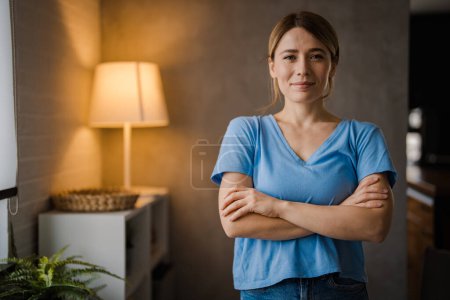 Photo for Young beautiful woman at home happy face smiling with crossed arms looking at the camera. Positive person. Portrait of smiling middle-aged woman. Happy friendly casual teen girl looking at camera, smiling cheerful woman - Royalty Free Image